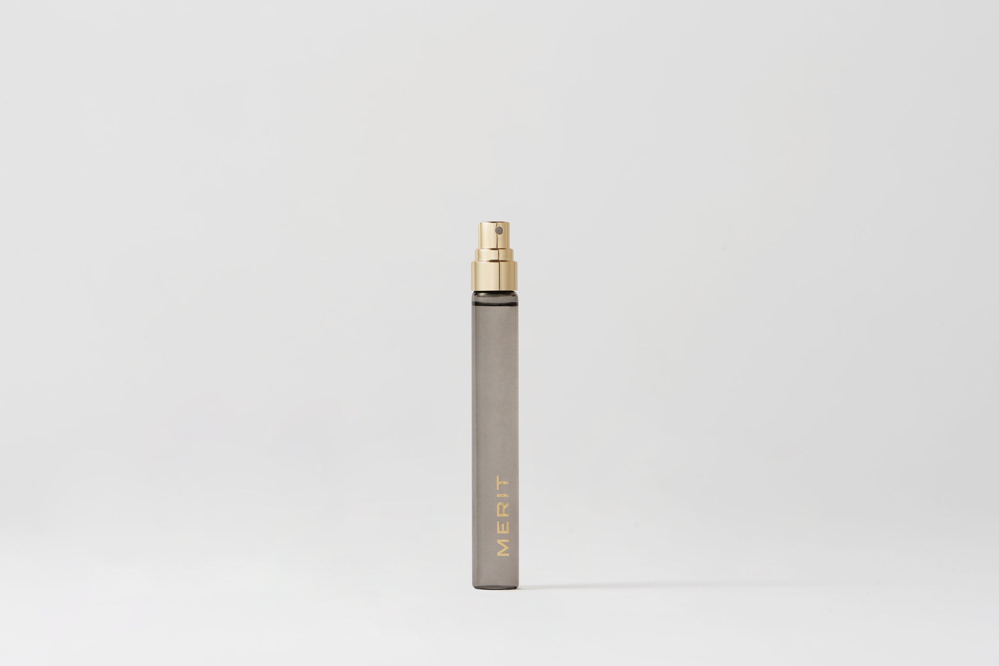 Master || Travel Bottle of Retrospect perfume with a gold sprayer and MERIT written on the front