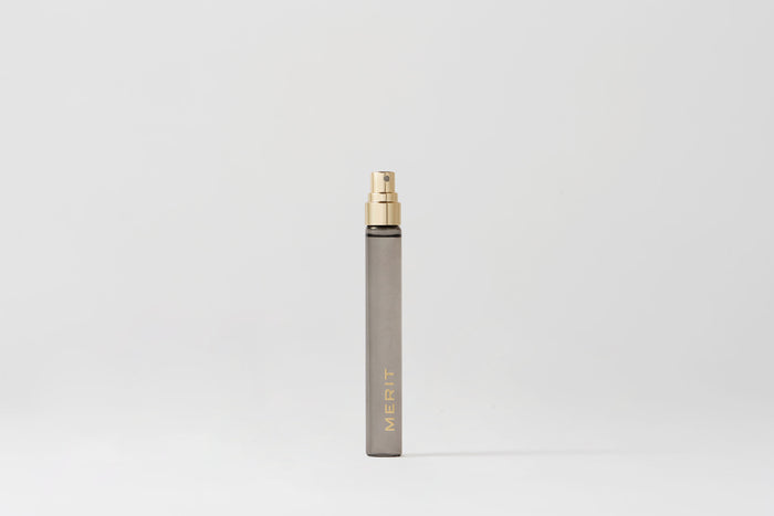 Master || Travel Bottle of Retrospect perfume with a gold sprayer and MERIT written on the front
