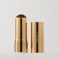 Monarch | |  A stick bronzer product by MERIT, with the cap off, showing the bronzing cream inside and MERIT on the cap. Shade Monarch