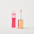 Master || A bottle of Merit lip oil in shade Les Deux displayed next to its applicator. 