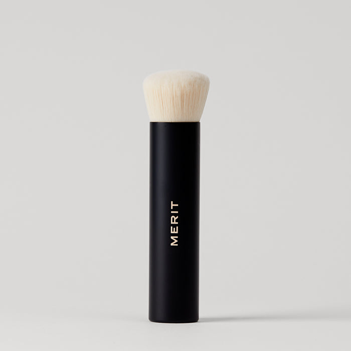 Master || A black makeup brush with a white bristle head, standing upright