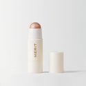 Master || A stick highlighter with the brand name MERIT written on it, with the product cap removed, revealing the highlighter balm in shade Bounce