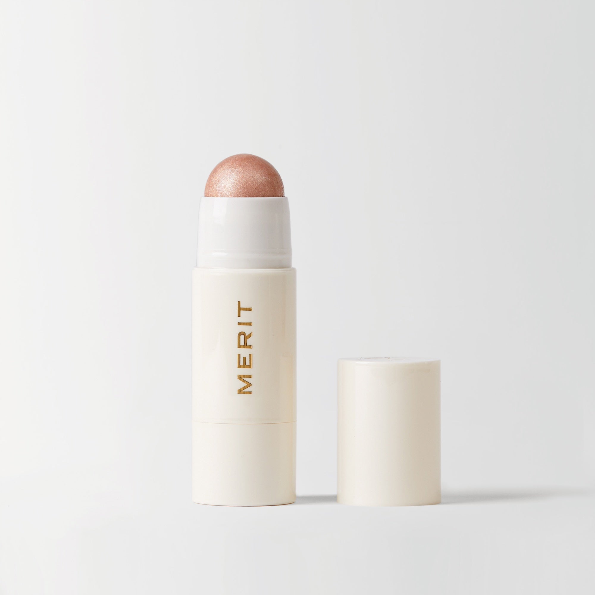Master || A stick highlighter with the brand name MERIT written on it, with the product cap removed, revealing the highlighter balm in shade Bounce