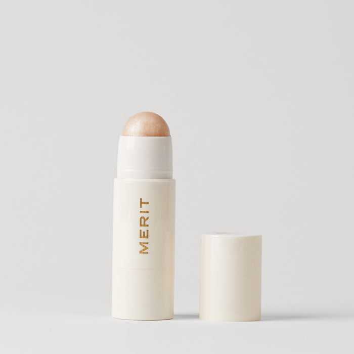 Master || A stick highlighter with the brand name MERIT written on it, with the product cap removed, revealing the highlighter balm in shade Cava