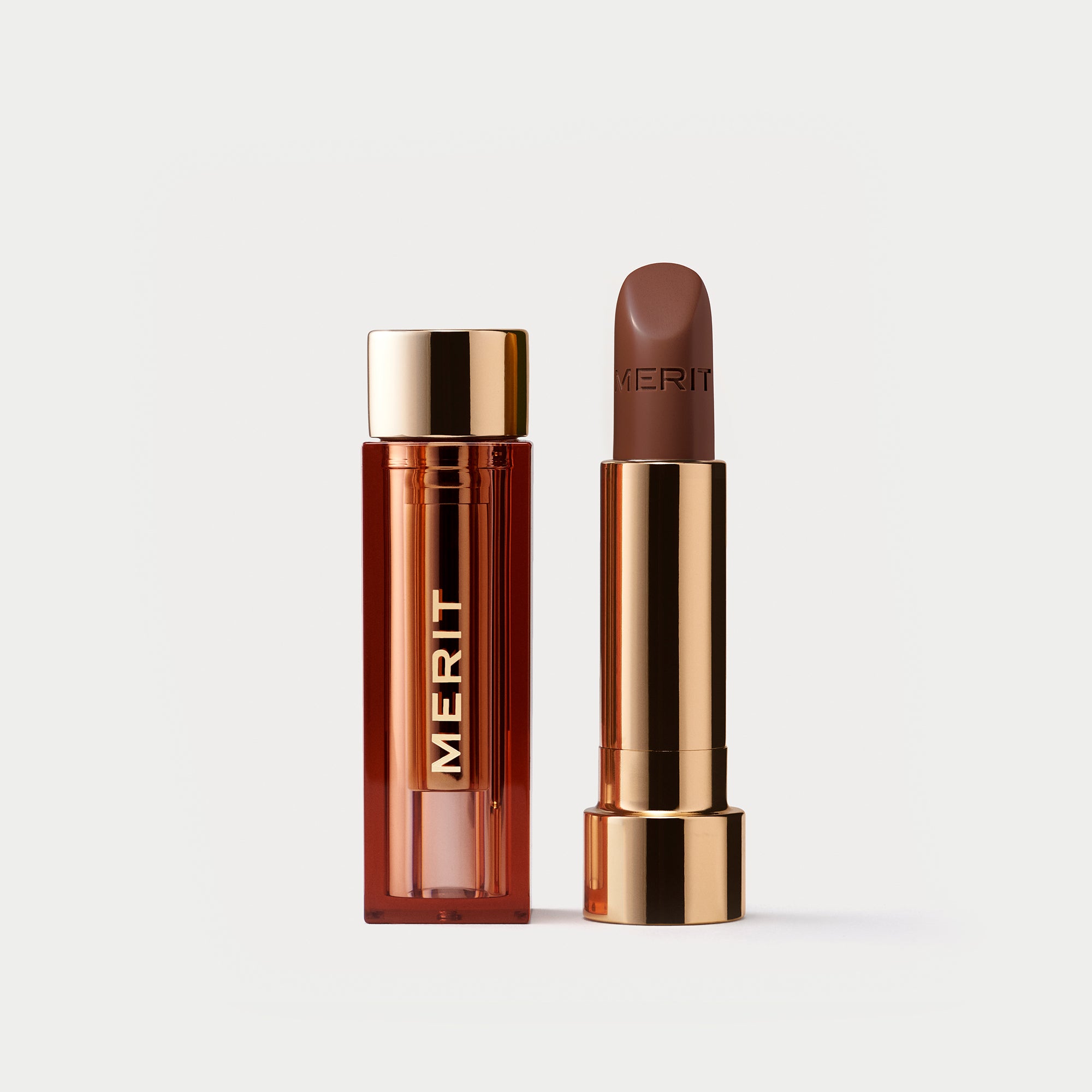 Master ||  A tube of lipstick in shade 1990 with a gold and brown cap next to its open container