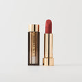 Master ||  A tube of lipstick in shade Court with a gold and brown cap next to its open container