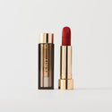 Master ||  A tube of lipstick in Power with a gold and brown cap next to its open container