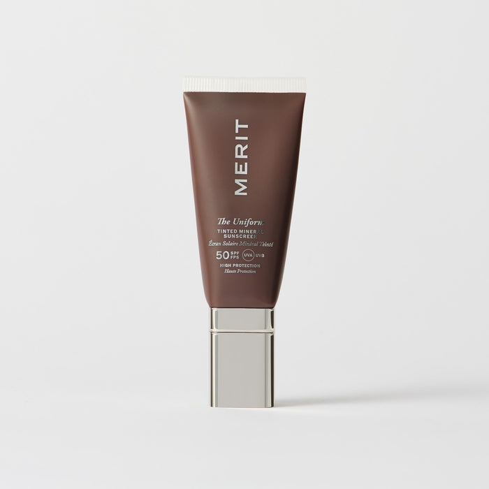 Master || A tube of MERIT brand mineral sunscreen with a sheer tint finish, providing broad spectrum 50 UVA/UVB protection, displayed against a white background. Shade 2