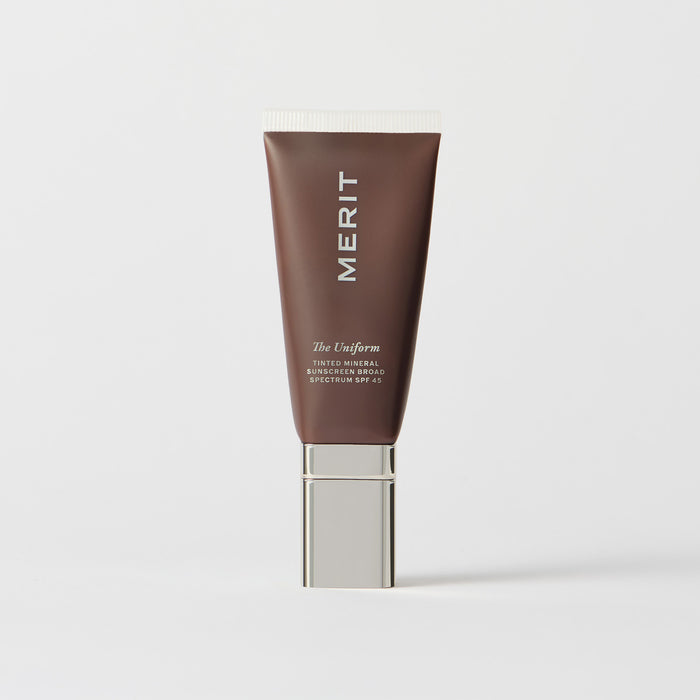 Master || A tube of MERIT brand mineral sunscreen with a sheer tint finish, providing broad spectrum 45 UVA/UVB protection, displayed against a white background. Shade 02