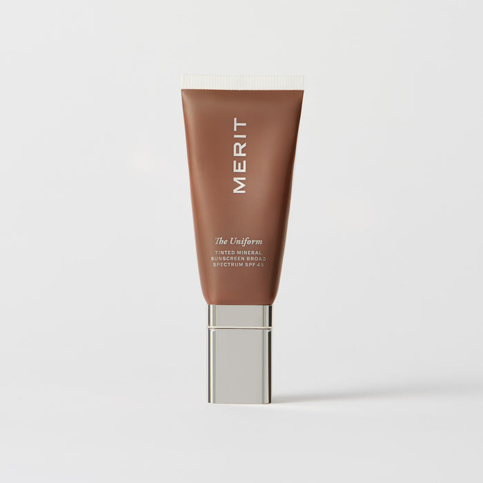 Master || A tube of MERIT brand mineral sunscreen with a sheer tint finish, providing broad spectrum 45 UVA/UVB protection, displayed against a white background.