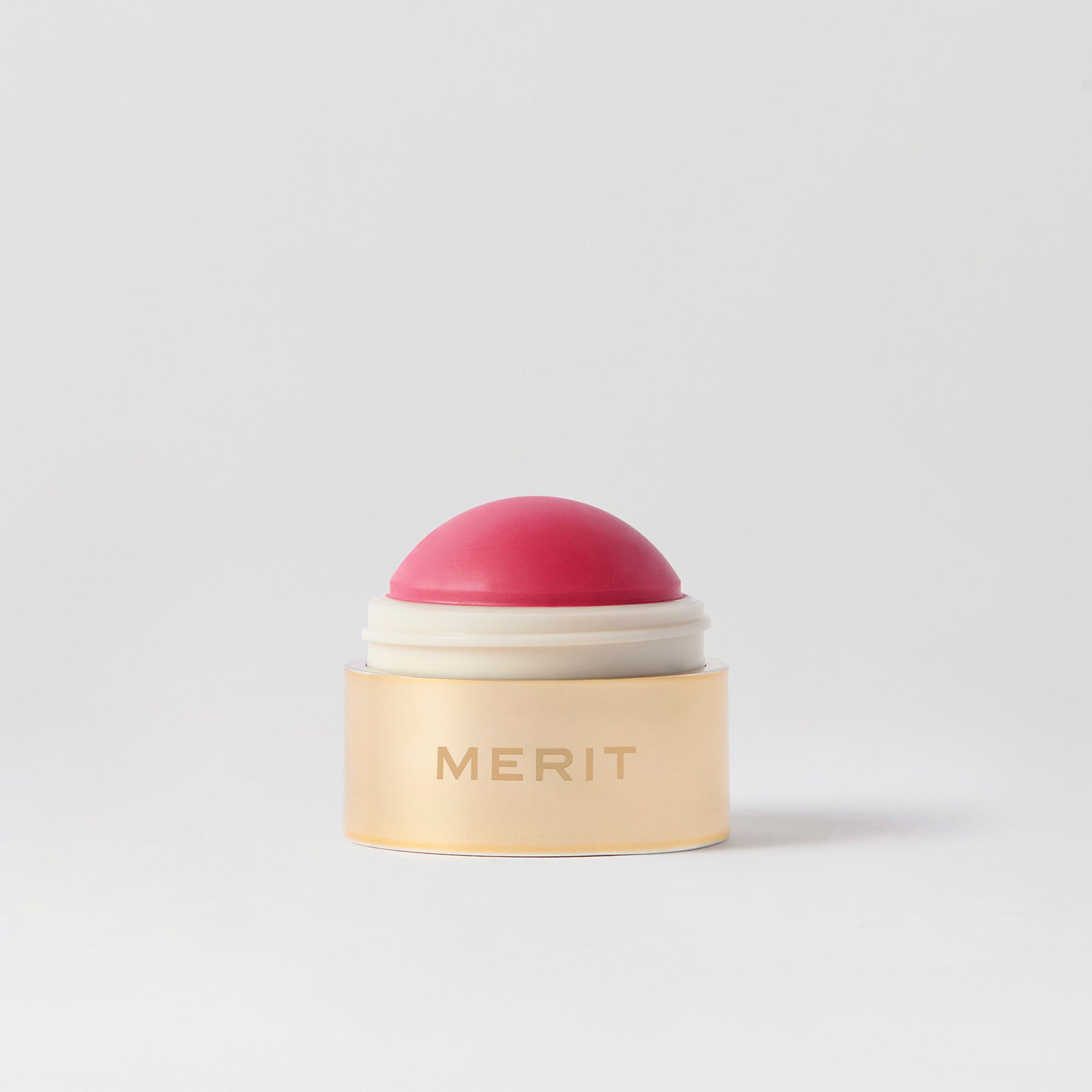 Master || A cream blush balm by Merit Beauty in color le bonbon and gold body