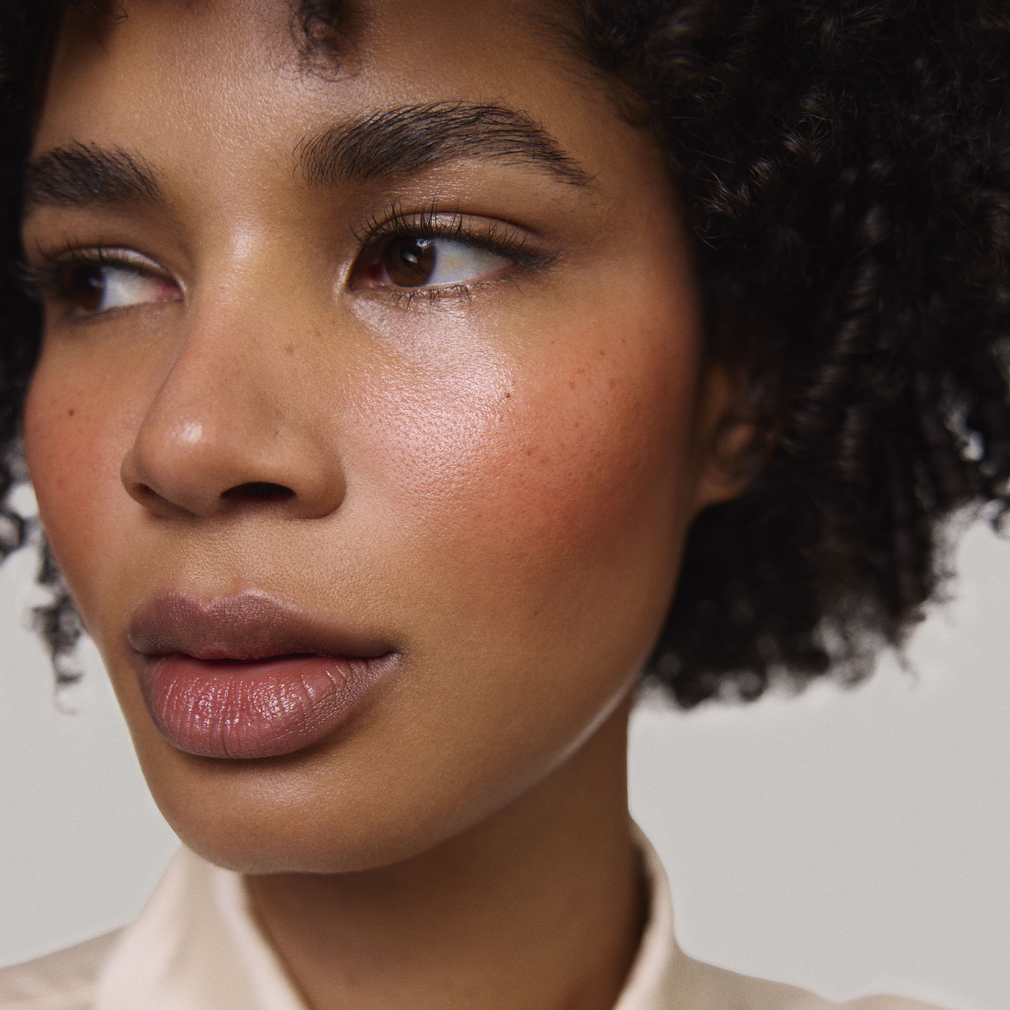 Persimmon | face::deep | Model is wearing Flush Balm in shade Persimmon
