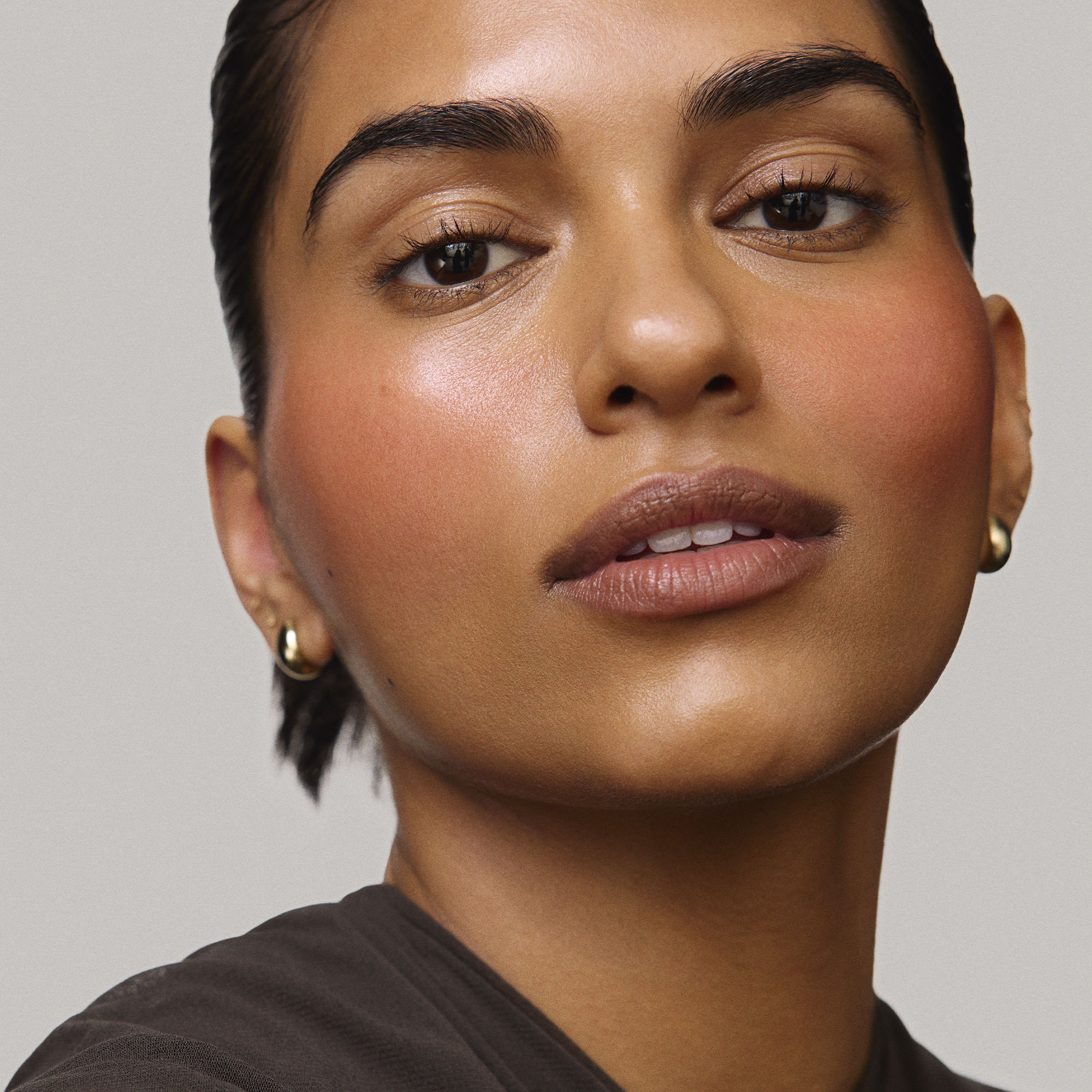 Persimmon | face::medium |  Model is wearing Flush Balm in shade Persimmon