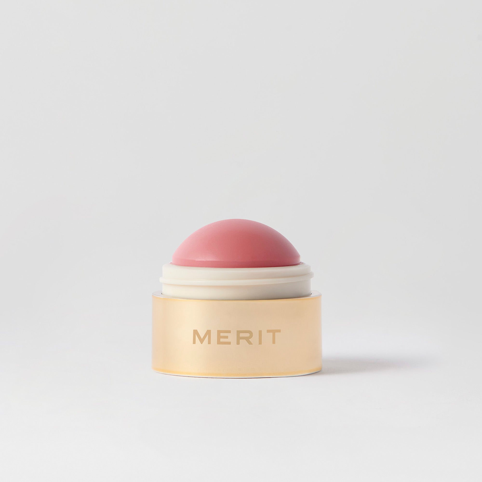 Master || A cream blush balm by Merit Beauty in color Stockholm and gold body, awarded 'Best of Beauty' by Allure in 2022.