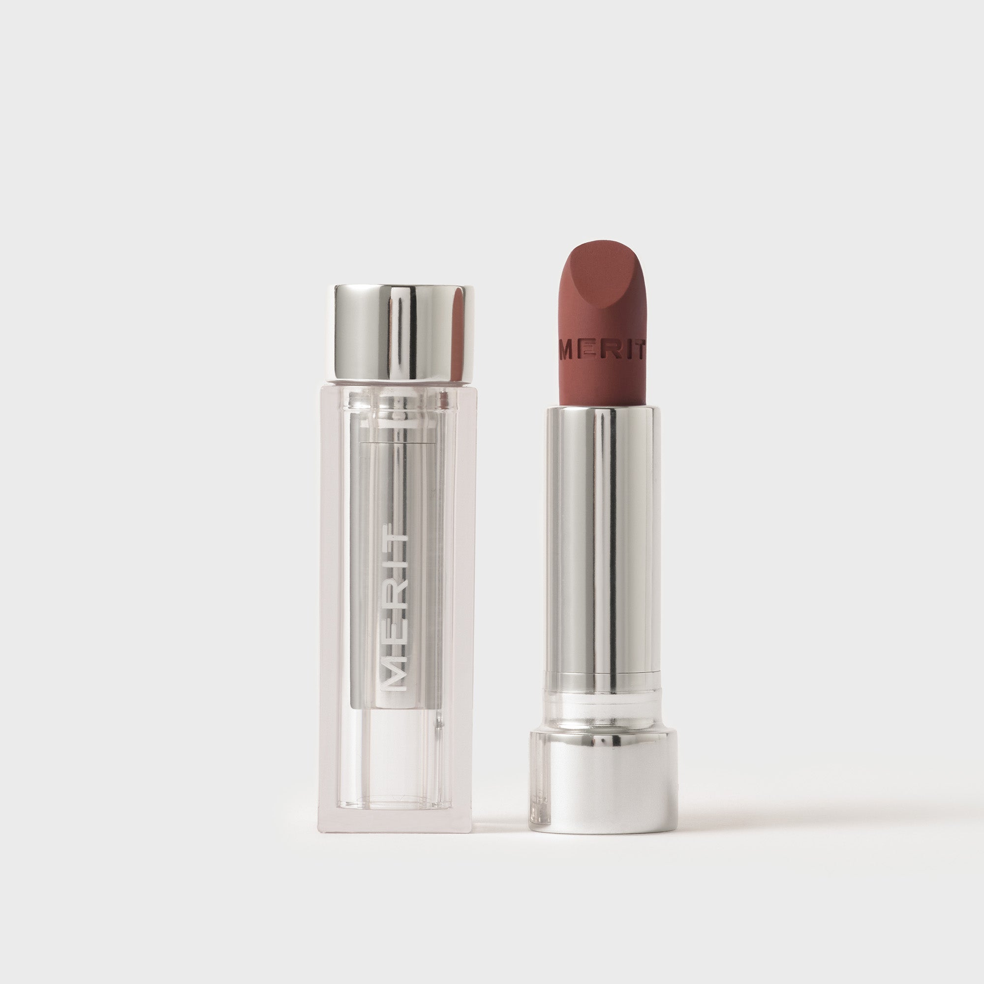 Merit Lipstick with silver case on a white background