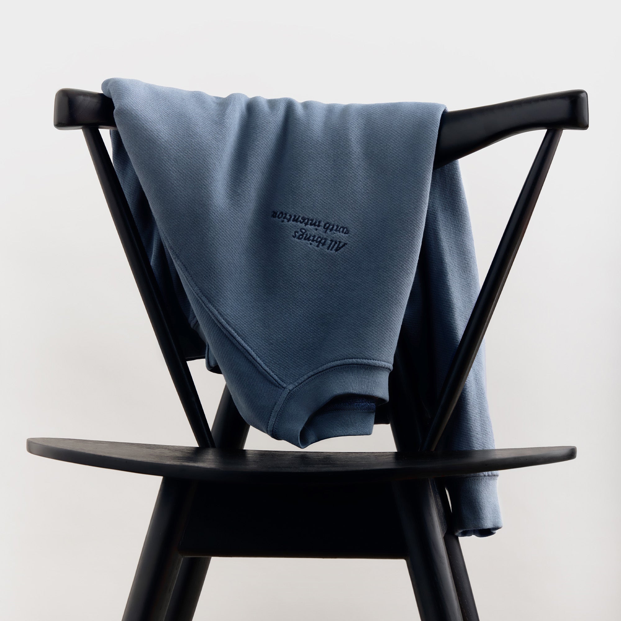 Master || The Anniversary Sweatshirt over a chair.