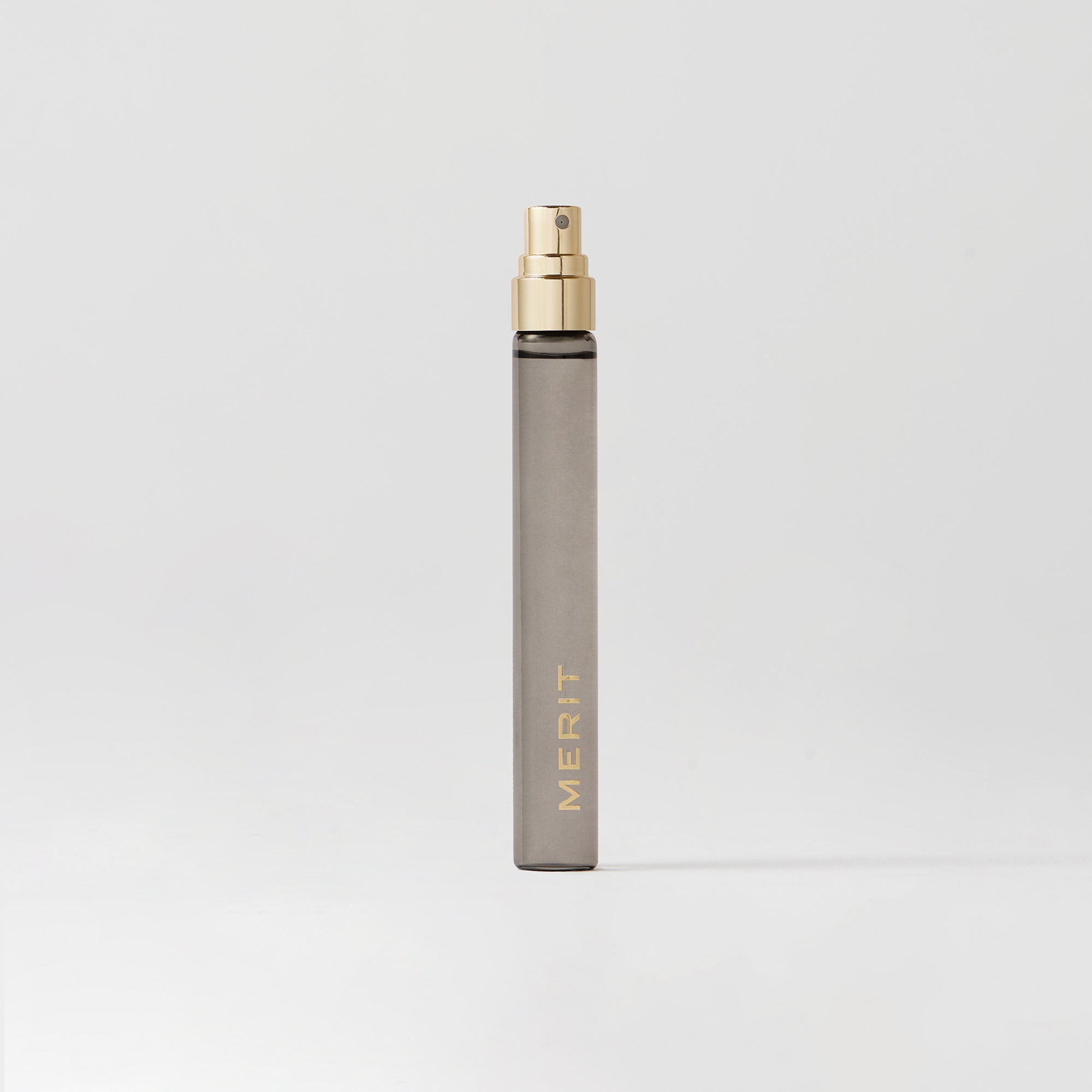 Master || Travel Bottle of Retrospect perfume with a gold sprayer and MERIT written on the front
