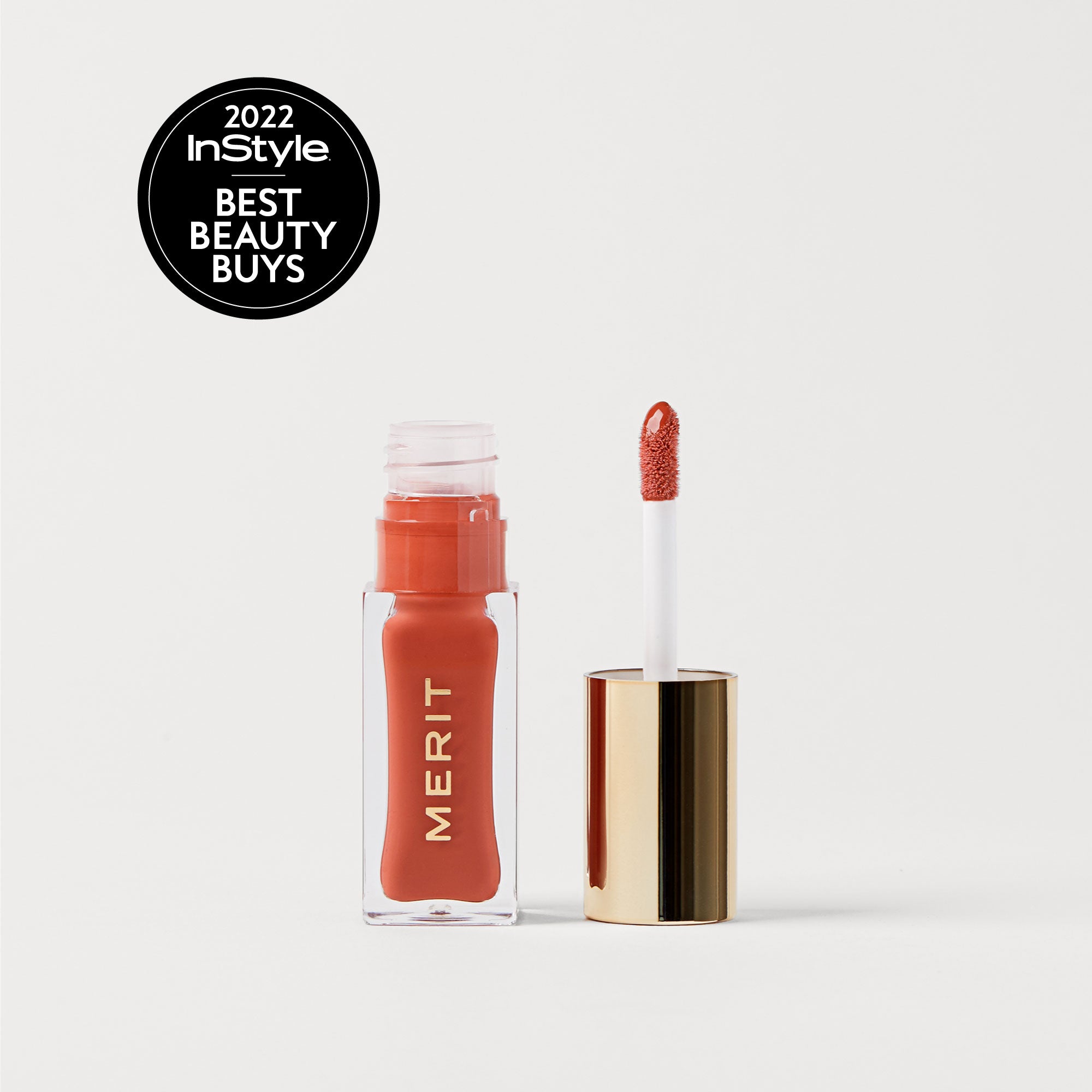 Marrakech | | A bottle of Merit lip oil in  shade Marrakech displayed next to its applicator. 2022 InStyle Best Beauty Buy