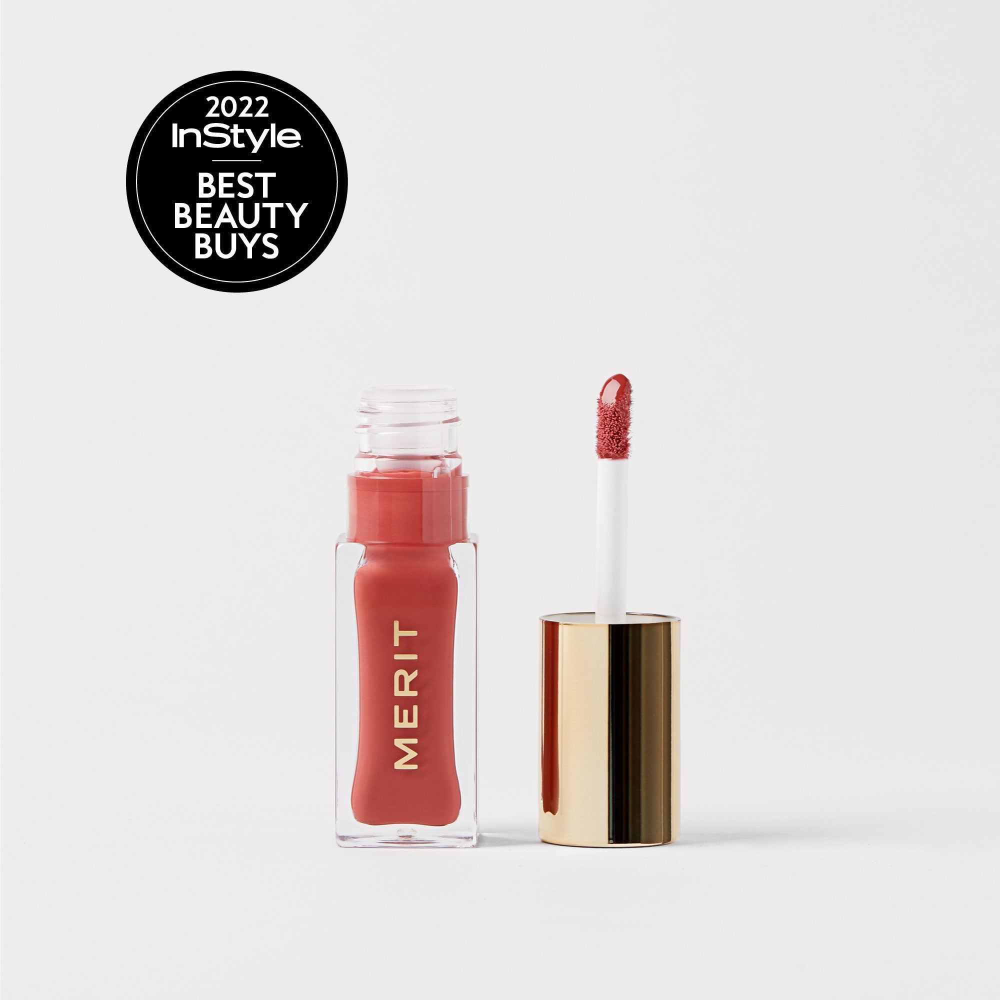Pink Beet | | A bottle of Merit lip oil in  shade Pink Beet displayed next to its applicator. 2022 InStyle Best Beauty Buy